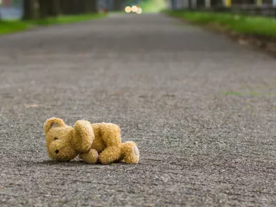 ﻿Teddy bear lies on the road