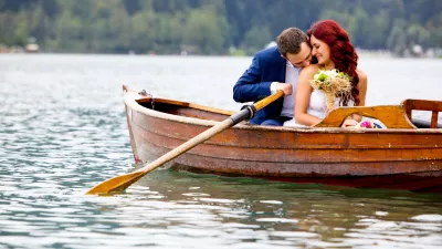 Young attractive wedding couple sharing love in a boat on beautiful lake / Foto: Jeliva