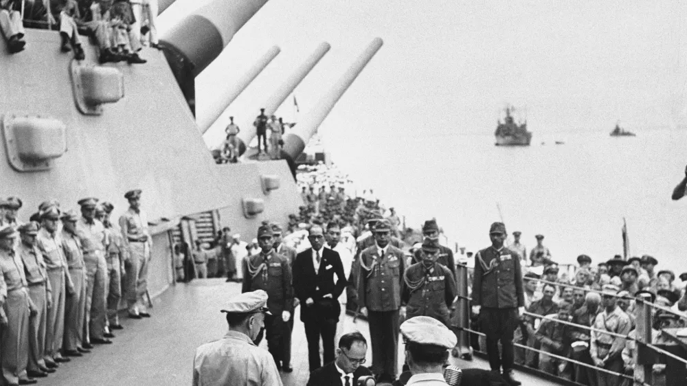 FILE- In this Sept. 2, 1945, file photo, then Japanese Foreign Minister Mamoru Shigemitsu signs Japanese Instrument of Surrender, a document signed on the deck of the USS Missouri in Tokyo Bay, Japan. (Pool Photo via AP, File)