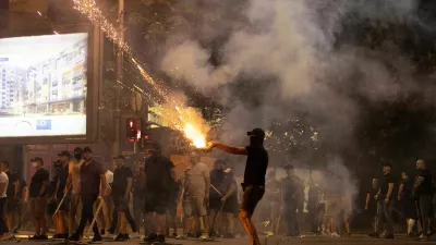 A person fires fireworks, during a standoff between supporters of the ruling party and anti-government protesters in Belgrade, Serbia, August 14, 2025. REUTERS/Djordje Kojadinovic