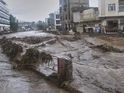 Local residents look at flash flooding due to heavy rains in a neighborhood of Mingora, the main town of Swat Valley, northwestern Pakistan, Friday, Aug. 15, 2025. (AP Photo/Naveed Ali)
