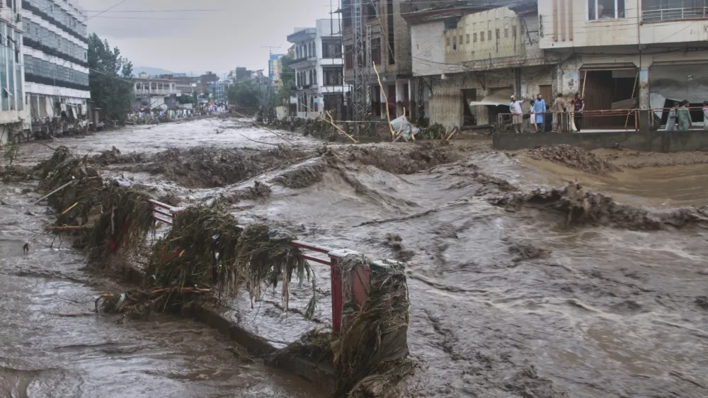 Local residents look at flash flooding due to heavy rains in a neighborhood of Mingora, the main town of Swat Valley, northwestern Pakistan, Friday, Aug. 15, 2025. (AP Photo/Naveed Ali)