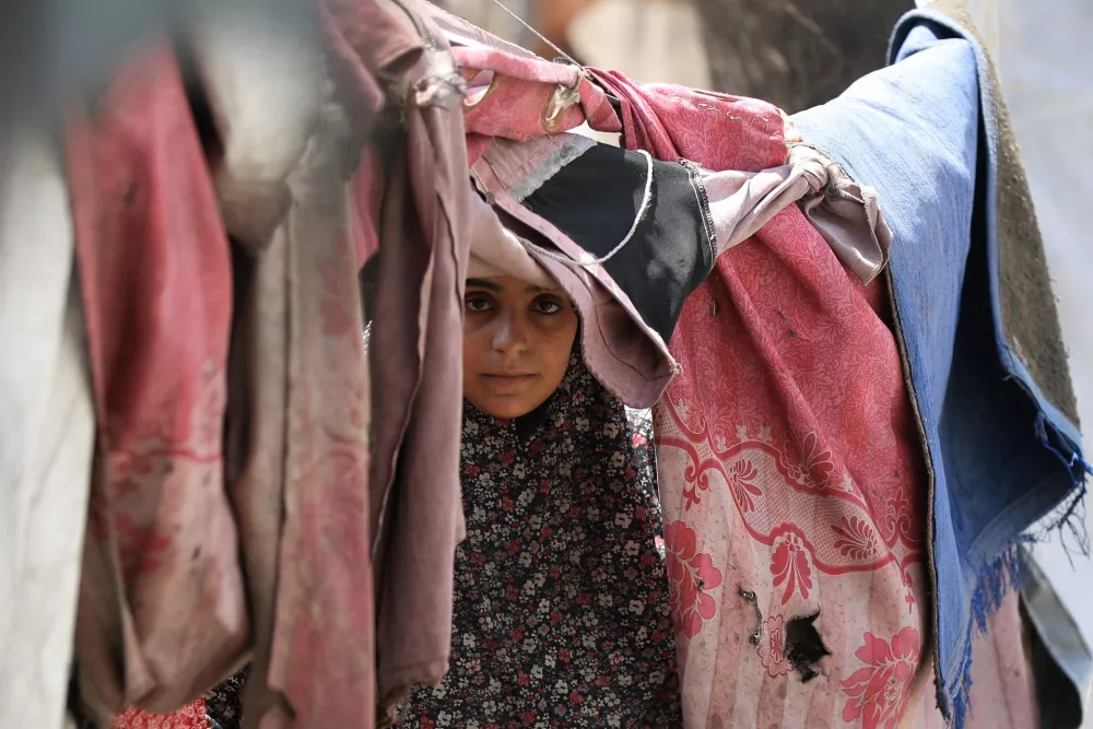 A Palestinian woman, displaced by the Israeli offensive, shelters in a tent camp as the Israeli military prepares to relocate residents to southern Gaza, in Gaza City August 17, 2025. REUTERS/Dawoud Abu Alkas