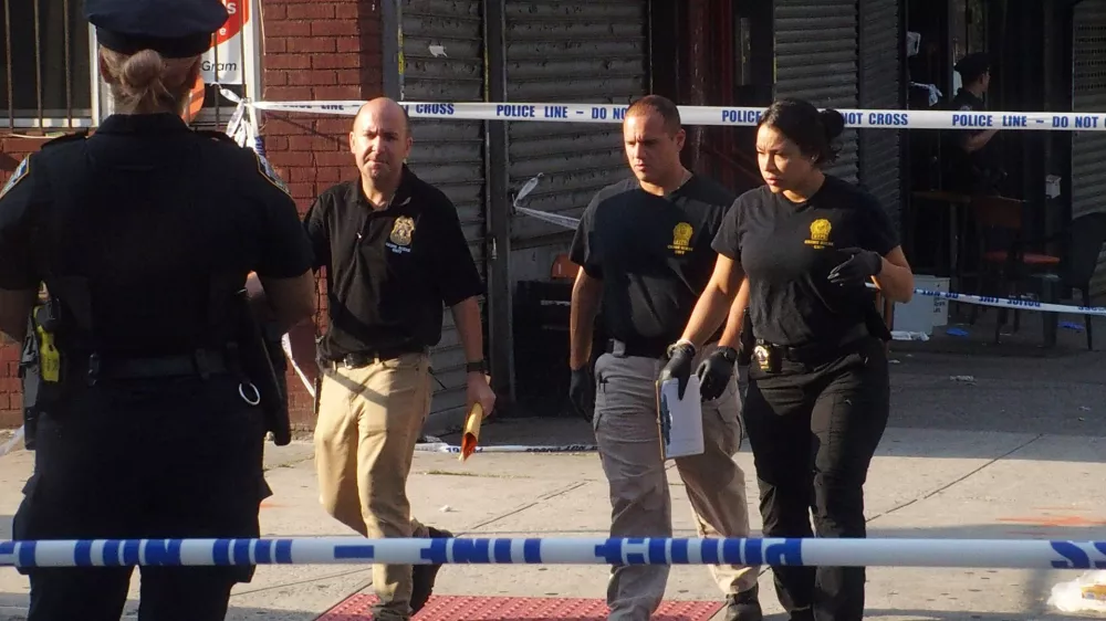 17 August 2025, US, BrooklynNew York City Police Department officers investigate the shooting scene at the 'Taste of the City' Lounge after multiple shooters open fire, leaving three dead and eight injuered. PhotoBruce Cotler/ZUMA Press Wire/dpa