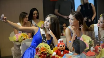 (From L to R) Miss Universe contestants Kseniya Alexandrova of Russia, Nicky Opheij of the Netherlands and Samantha James of Malaysia take a selfie with children from an orphanage during a visit to a popular fast food restaurant in Manila on December 7, 2017. Miss Universe Demi-Leigh Nel-Peters of South Africa and other pageant contestants are in Manila for a visit after the contest in Las Vegas last month.,Fotografija:357133851, Licenca:Rights-managed, Omejitve:, Model izdaje:no
