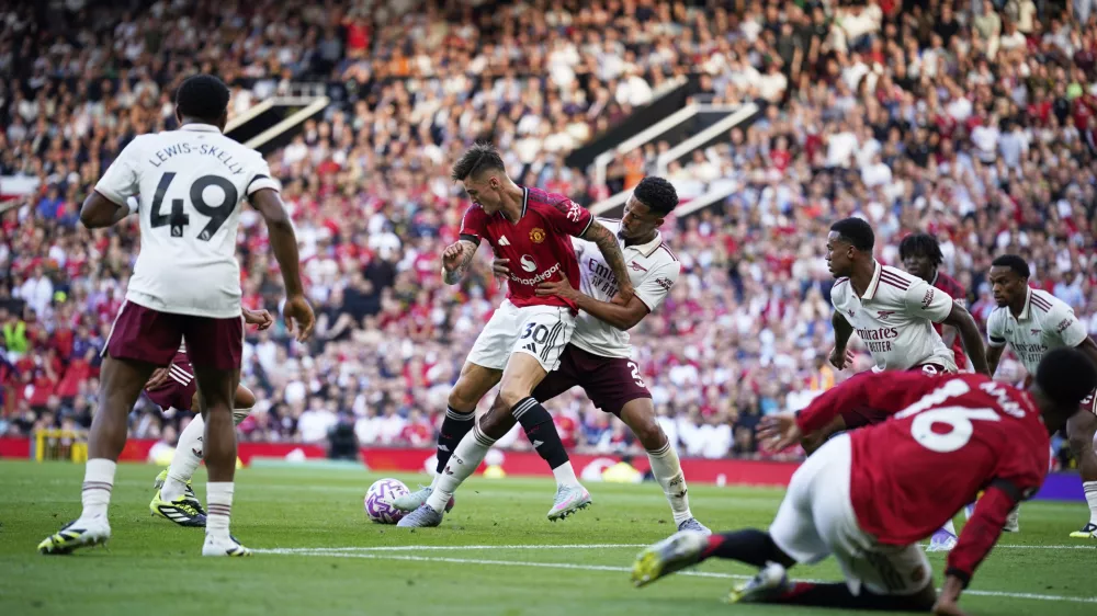 Arsenal's William Saliba, ceter right, challenges Manchester United's Benjamin Sesko during the English Premier League soccer match between Manchester United and Arsenal at Old Trafford stadium in Manchester, England, Sunday, Aug. 17, 2025. (AP Photo/Dave Thompson)