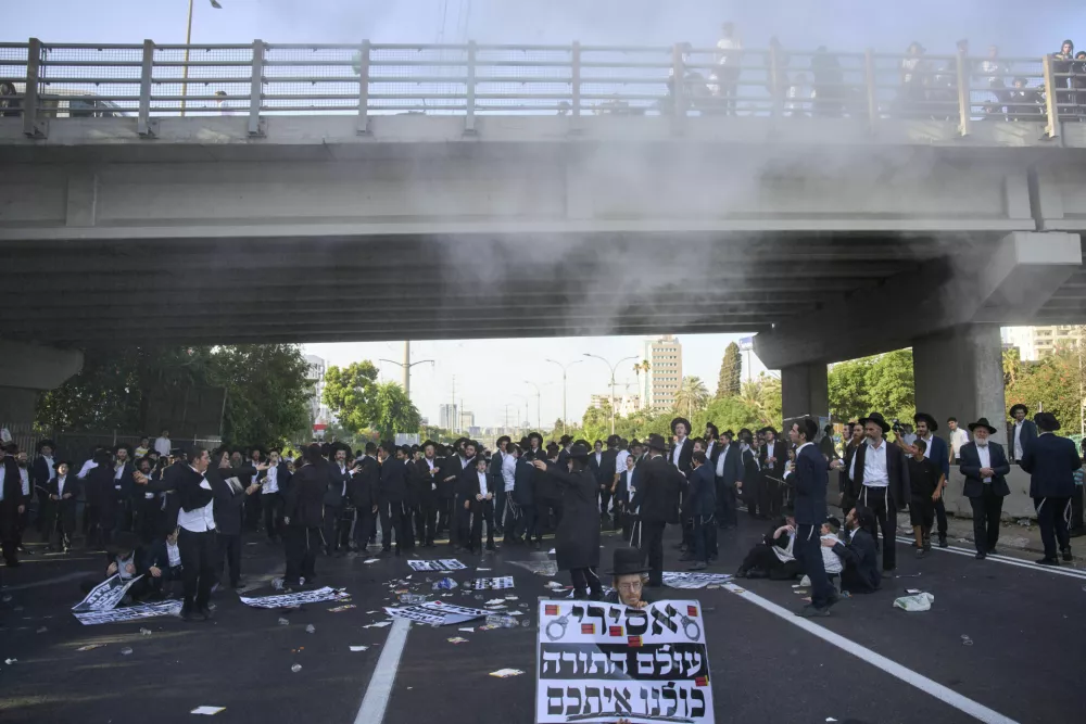 Ultra-Orthodox Jews block a highway during a protest against army recruitment, in Bnei Brak, Israel, Tuesday, Aug. 19, 2025. (AP Photo/Ohad Zwigenberg)
