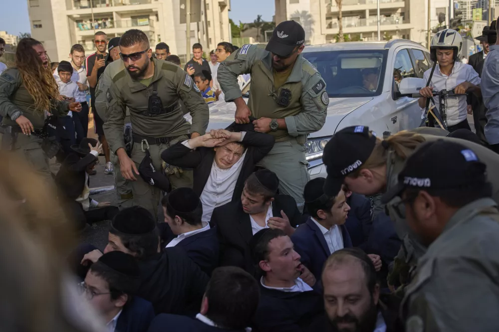 Police disperse ultra-Orthodox Jews blocking a highway during a protest against army recruitment, in Bnei Brak, Israel, Tuesday, Aug. 19, 2025. (AP Photo/Ohad Zwigenberg)