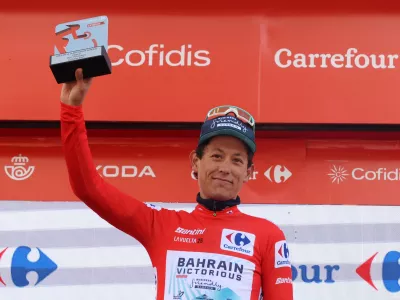 Cycling - Vuelta a Espana - Stage 6 - Olot to Pal - Olot, Andorra - August 28, 2025 Bahrain Victorious' Torstein Traeen celebrates on the podium with a trophy and the red jersey after stage 6 REUTERS/Bruna Casas