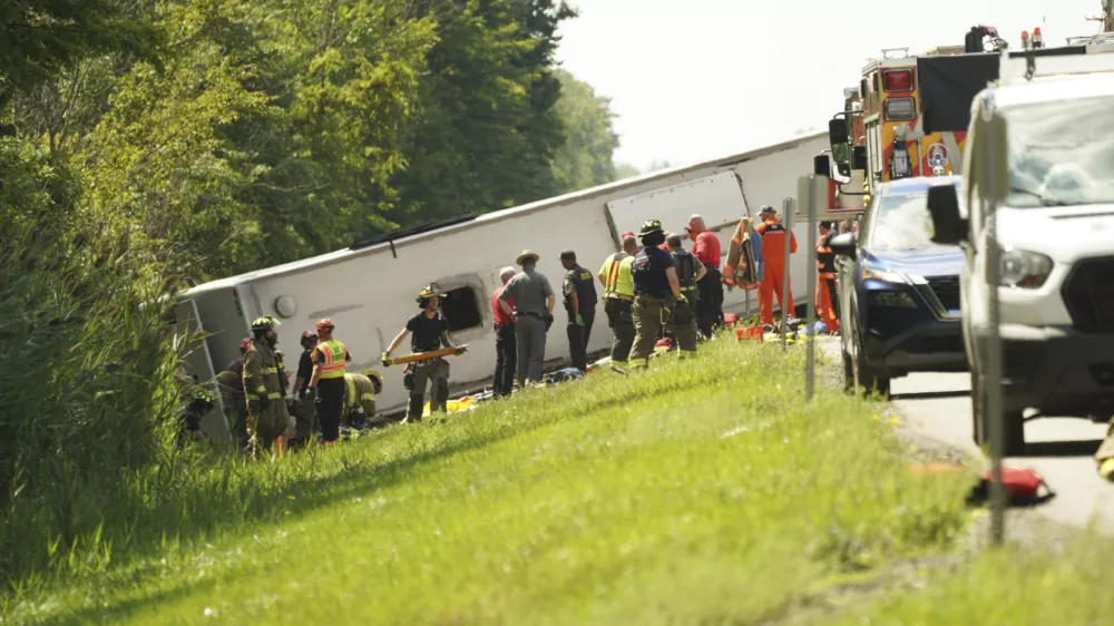First responders work to rescue victims at the scene of a tour bus that crashed and rolled over on the New York State Thruway near Pembroke, N.Y., Friday, Aug. 22, 2025. (Libby March/Buffalo News via AP)