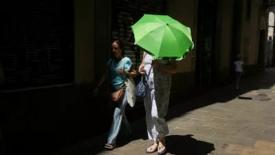 A woman carries an umbrella for shade from the heat as she walks around El Born, in Barcelona, Spain, August 9, 2025. REUTERS/Bruna Casas