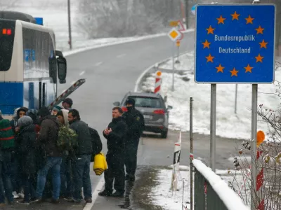 ﻿Migrants walk during snowfall before passing Austrian-German border in Wegscheid in Austria, near Passau November 22, 2015. REUTERS/Michael Dalder - RTX1VA39