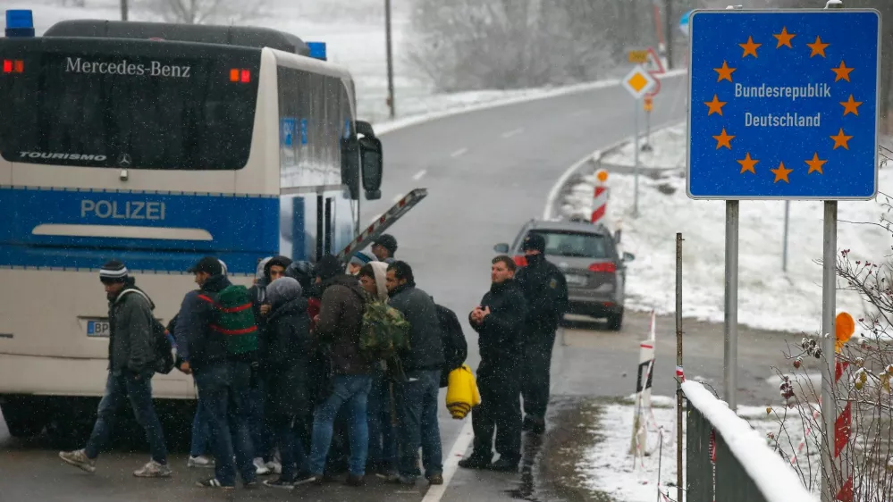 ﻿Migrants walk during snowfall before passing Austrian-German border in Wegscheid in Austria, near Passau November 22, 2015. REUTERS/Michael Dalder - RTX1VA39