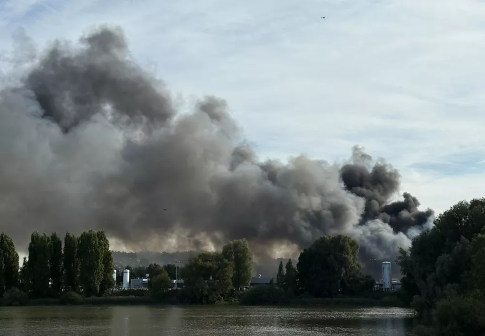 25 August 2025, Hamburg: A large cloud of smoke can be seen over the city of Hamburg. A fire has broken out in a warehouse in the Port of Hamburg, causing a major motorway nearby to be closed. Photo: Daniel Bockwoldt/dpa