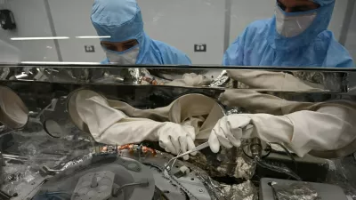 Strokovnjaka za obdelavo astromaterialov, Mari Montoya (levo) in Curtis Calva (desno), z orodjem zbirata delce asteroida z dna znanstvenega vsebnika misije OSIRIS-REx. / Foto: Nasa