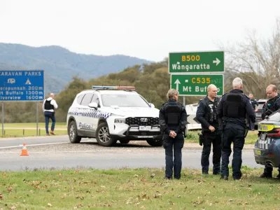 Victorian Police stand at the scene of a shooting in Porepunkah, Victoria, Australia, August 26, 2025. Parts of a rural town, including a primary school, have been placed into lockdown after two police officers were reportedly shot dead and a third critically injured. AAP/Simon Dallinger via REUTERS  ATTENTION EDITORS - THIS IMAGE WAS PROVIDED BY A THIRD PARTY. NO RESALES. NO ARCHIVE. AUSTRALIA OUT. NEW ZEALAND OUT. NO COMMERCIAL OR EDITORIAL SALES IN NEW ZEALAND. NO COMMERCIAL OR EDITORIAL SALES IN AUSTRALIA.
