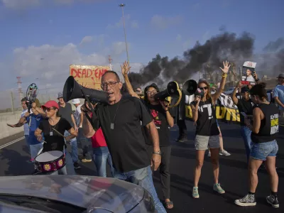 Activists block a highway during a protest demanding the immediate release of hostages held by Hamas and calling for the Israeli government to reverse its decision to take over Gaza City and other areas in the Gaza Strip, near the city of Lod, Israel, Tuesday, Aug. 26, 2025. (AP Photo/Ohad Zwigenberg)