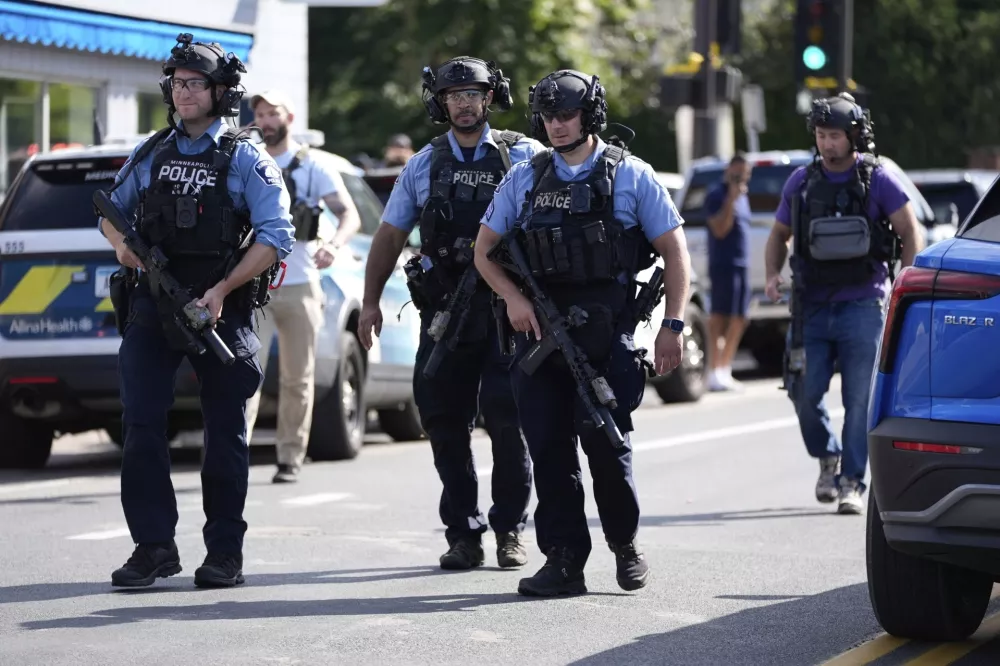 Law enforcement officers gather outside the Annunciation Church's school in response to a reported mass shooting, Wednesday, Aug. 27, 2025, in Minneapolis. (AP Photo/Abbie Parr)