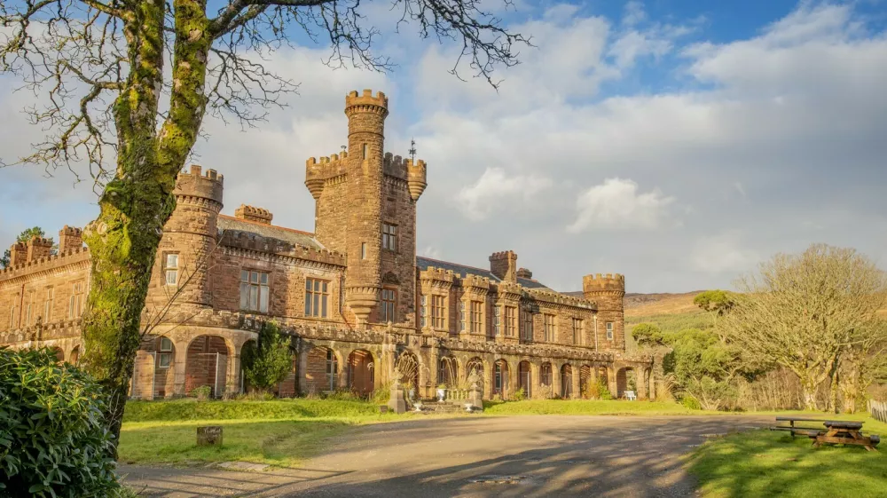 Kinloch Castle. See SWNS story SWOCcastle. July 29, 2021.One of Prince Charles' favourite castles is looking for a new owner to save it from ruin as the iconic landmark crumbles in need of repair. Kinloch Castle on the Island of Rum in Scotland is on the market for a new owner who could put the money required into fixing up the crumbling castle. With a nominal value of just £1, this is an extremely rare opportunity to take ownership of a 120-year-old castle that Prince Charles himself has been passionate about saving. Repairs on the crumbling turreted red-sandstone house are estimated at an eye-watering £20 million to restore the castle to it's former glory. A private individual or a charity, foundation or private company who can provide such an amount for the castle repairs are in with a chance of owning the incredible house. Any new hopeful owners will have to prove that they have the resources to save this Category A landmark and show plans for bettering the future of the small isle where the castle sits.,Image: 624152990, License: Rights-managed, Restrictions: This image is not available for use at a stock rate unless with prior agreement. This image hereby disclosed to your organisation is so disclosed on the condition that your organisation will take all steps necessary to ensure that any identifiable personal data is processed in full compliance with the Data Protection Act 2018follow us on twitter - @swnsbrowse our website - swns.comemail pix@swns.com, Model Release: no