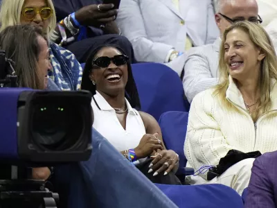 Gymnast Simone Biles, center, reacts after Coco Gauff, of the United States, mentioned her following Gauff's match against Donna Vekic, of Croatia, during the second round of the U.S. Open tennis championships, Thursday, Aug. 28, 2025, in New York. (AP Photo/Frank Franklin II)