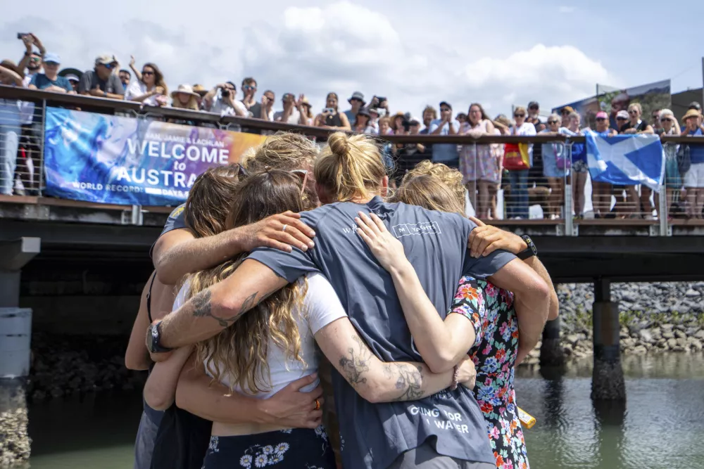 Scottish brothers, Ewan, Jamie and Lachlan, Maclean are embraced by family after completing their record breaking row from Peru across the Pacific Ocean to Cairns, Australia, Saturday, Aug. 30, 2025. (Nuno Avendano/AAP Image via AP)