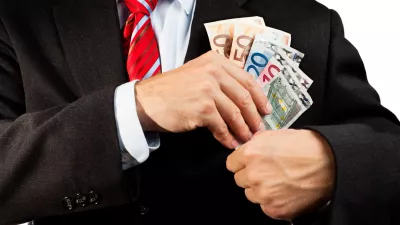 Businessman putting money (euro banknotes) in his pocket. / Foto: Ellobo1