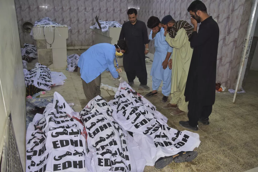 People identify the bodies of the victims of suicide bombing in a morgue of a hospital in Quetta, Pakistan, Tuesday, Sept. 2, 2025. (AP Photo/Arshad Butt)