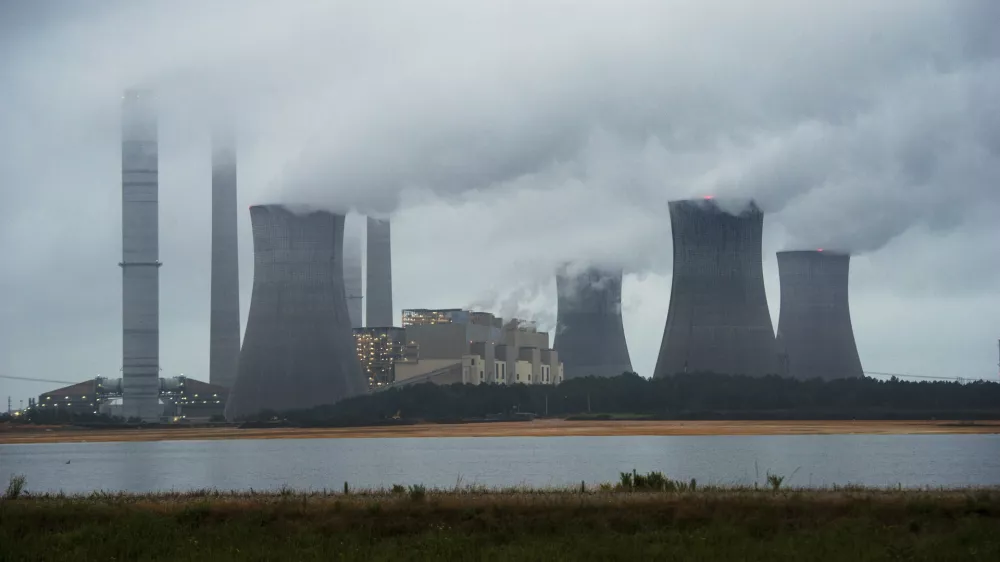 ﻿FILE - This June 1, 2014, file photo show the coal-fired Plant Scherer in operation in Juliette, Ga. Despite what President Donald Trump says, scientists have long known that what's warming the planet isn't natural. It's us. Climate scientists say Trump was wrong. There are several ways they know that more than 90 percent of climate change is caused by emissions of heat-trapping gases from activities like burning coal and natural gas for electricity, or burning gasoline, diesel and jet fuel for transportation. In other words, humans. (AP Photo/John Amis, File)