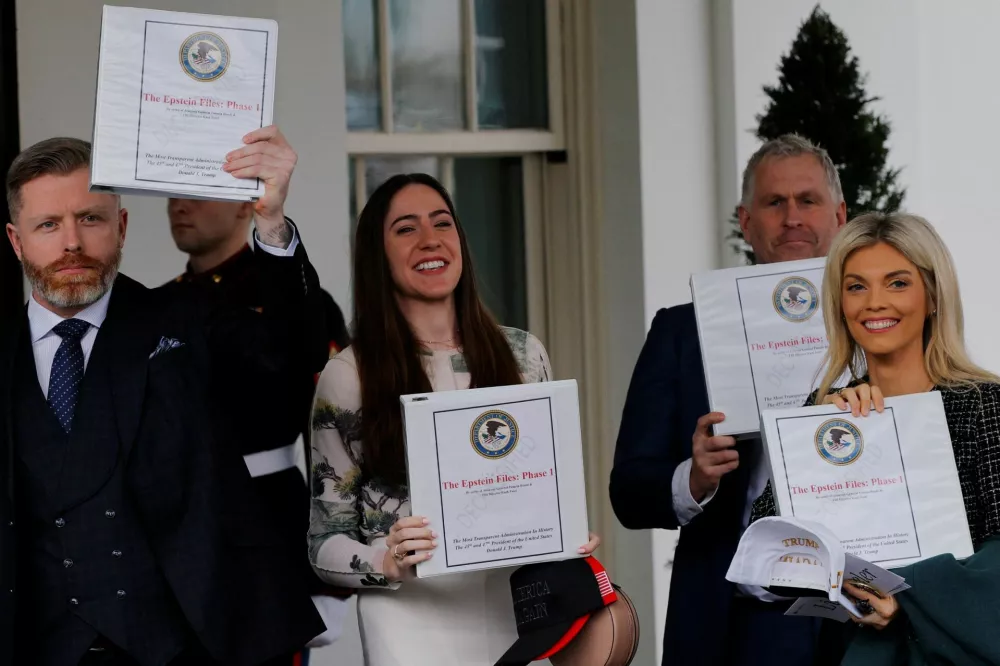 FILE PHOTO: A group walks out of the West Wing holding up binders labelled "The Epstein Files: Phase 1", at the White House in Washington, D.C., U.S., February 27, 2025. REUTERS/Brian Snyder/File Photo