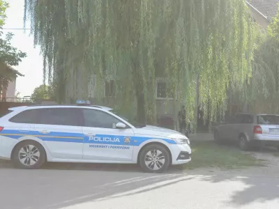 Policijski avto pred hišo, v greznici katere naj bi našli truplo pogrešane ženske. 