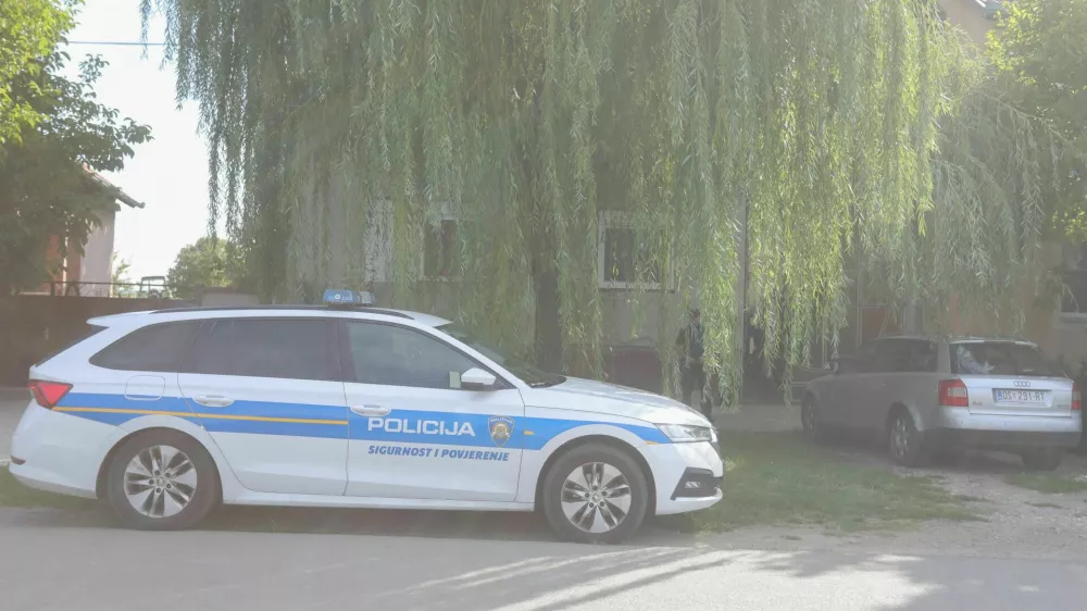 Policijski avto pred hišo, v greznici katere naj bi našli truplo pogrešane ženske. 