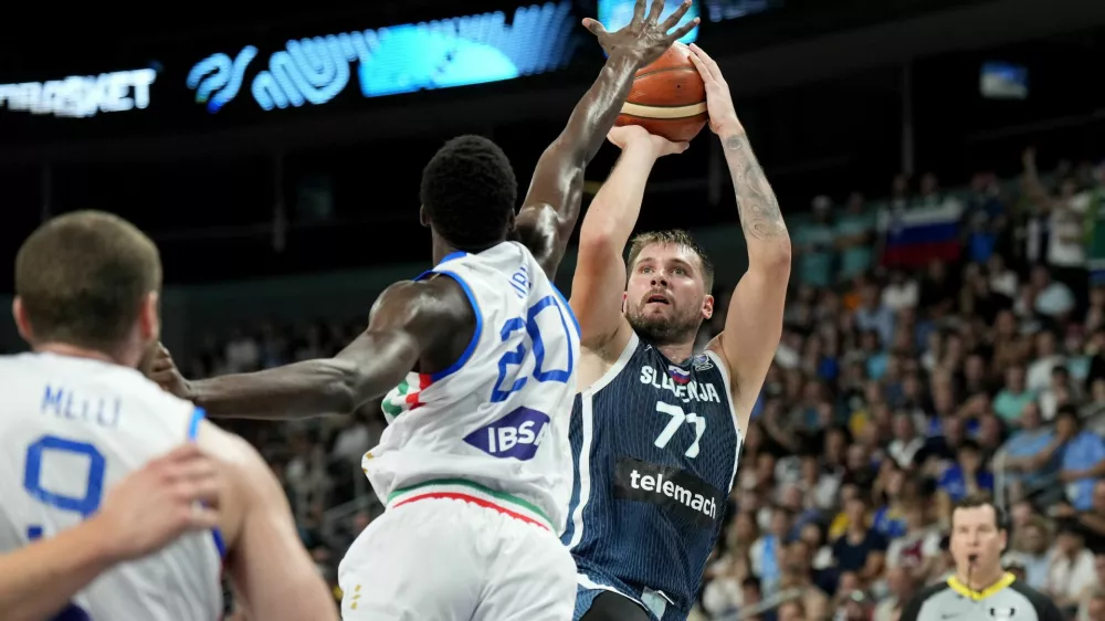 Basketball - FIBA EuroBasket 2025 - Round of 16 - Italy v Slovenia - Xiaomi Arena, Riga, Latvia - September 7, 2025 Italy's Saliou Niang in action with Slovenia's Luka Doncic REUTERS/Ints Kalnins