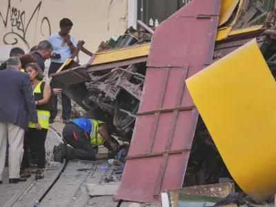 Police officers inspect the site where a tourist streetcar derailed and crashed in Lisbon, Portugal, Thursday, Sept. 4, 2025. (AP Photo/Armando Franca)
