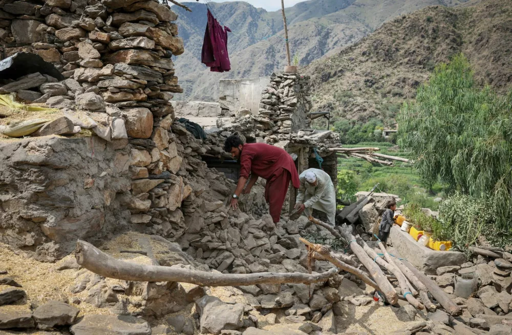Afghan men look for their belongings amidst the rubble of a collapsed house after a deadly magnitude 6 earthquake that struck Afghanistan on Sunday, at Lulam village, in Nurgal district, Kunar province, Afghanistan, September 3, 2025. REUTERS/Sayed Hassib