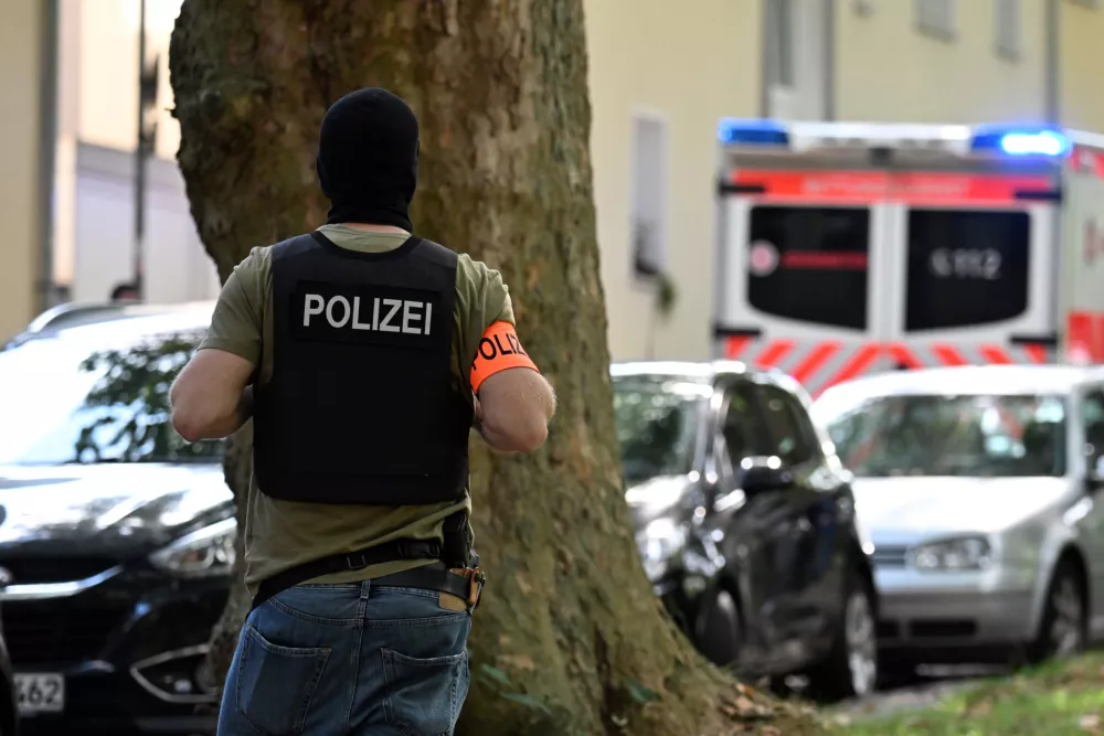 05 September 2025, North Rhine-Westphalia, Essen: A police officer secures the scene of an arrest. Following the knife attack on a teacher at a vocational college in Essen, a suspect has been arrested, the Essen police confirmed to the German Press Agency. Photo: Federico Gambarini/dpa