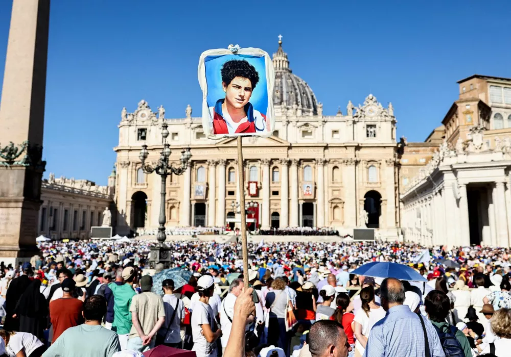 A person holds up an artwork on the day Pope Leo XIV leads a Holy Mass for the canonisation of Carlo Acutis, a British-born Italian boy who will become the first millennial to be made a Catholic saint, and Pier Giorgio Frassati, in St. Peter's Square at the Vatican, September 7, 2025. REUTERS/Matteo Minnella   TPX IMAGES OF THE DAY