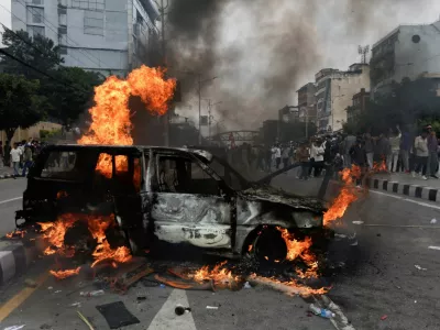People stand near a vehicle torched by the demonstrators during a protest against corruption and the government's decision to block several social media platforms, in Kathmandu, Nepal, September 8, 2025. REUTERS/Navesh Chitrakar
