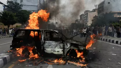 People stand near a vehicle torched by the demonstrators during a protest against corruption and the government's decision to block several social media platforms, in Kathmandu, Nepal, September 8, 2025. REUTERS/Navesh Chitrakar