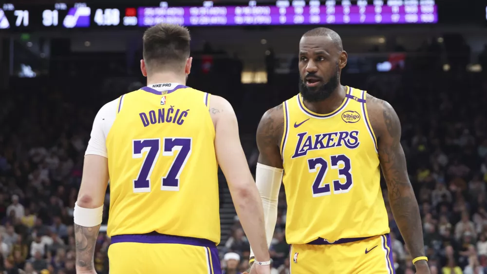 Los Angeles Lakers forward LeBron James (23) slaps hands with guard Luka Doncic (77) during the second half of an NBA basketball game against the Utah Jazz, Wednesday, Feb. 12, 2025, in Salt Lake City. (AP Photo/Rob Gray)