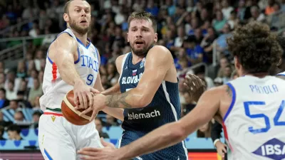 Basketball - FIBA EuroBasket 2025 - Round of 16 - Italy v Slovenia - Xiaomi Arena, Riga, Latvia - September 7, 2025 Italy's Nicolo Mell in action with Slovenia's Luka Doncic REUTERS/Ints Kalnins
