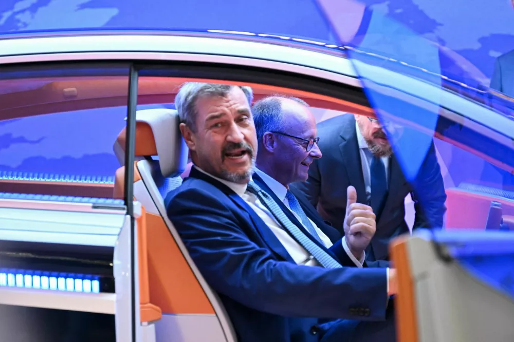 German Chancellor Friedrich Merz and Bavarian State Premier Markus Soeder sit inside a Qualcomm concept car at the IAA Mobility 2025 auto show in Munich, Germany, September 9, 2025. REUTERS/Angelika Warmuth