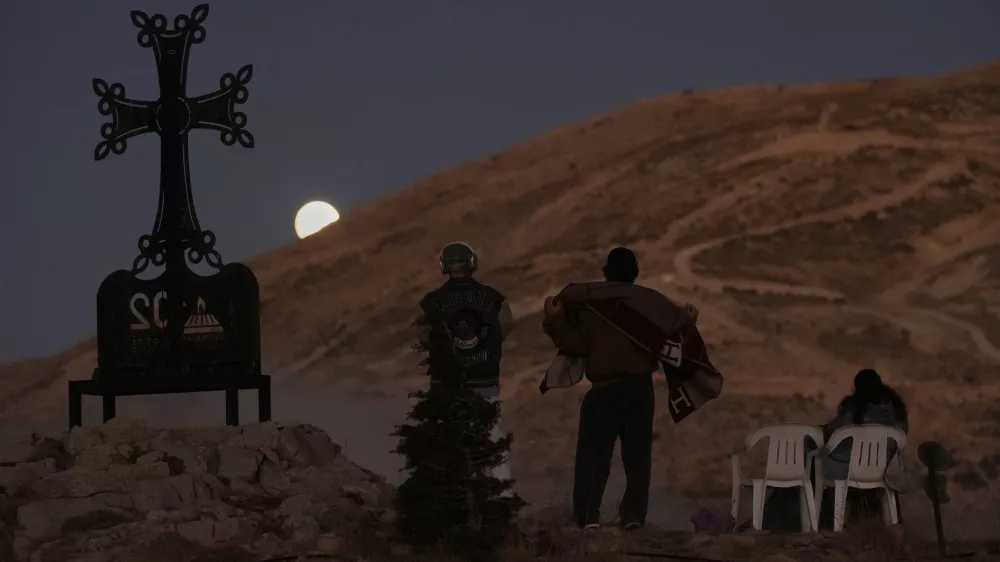 People watch as the moon shines during a total lunar eclipse over Kfardebian village, northeast of Beirut, Lebanon, Sunday, Sept. 7, 2025. (AP Photo/Bilal Hussein) / Foto: Bilal Hussein