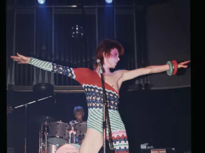 Bowie, ki nastopa kot Ziggy Stardust v asimetrični kombinezonu, ki ga je oblikoval Kansai Yamamoto. F V&A Collections 