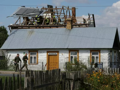 Polish soldiers walk below as firefighters work on the destroyed roof of a house, after Russian drones violated Polish airspace during an attack on Ukraine, with some being shot down by Poland with the backing from its NATO allies, in Wyryki, Lublin Voivodeship, Poland, September 10, 2025. REUTERS/Kacper Pempel