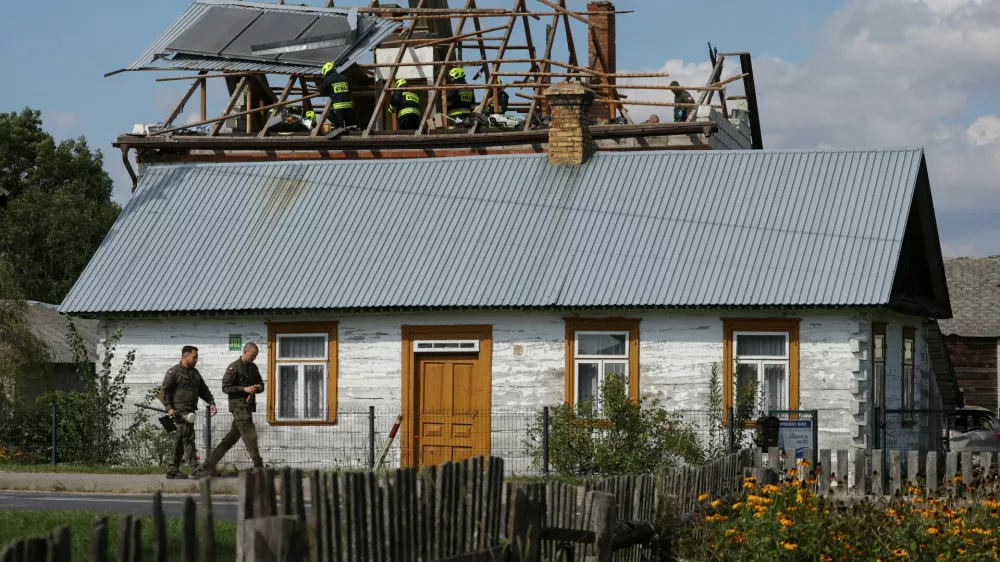 Polish soldiers walk below as firefighters work on the destroyed roof of a house, after Russian drones violated Polish airspace during an attack on Ukraine, with some being shot down by Poland with the backing from its NATO allies, in Wyryki, Lublin Voivodeship, Poland, September 10, 2025. REUTERS/Kacper Pempel