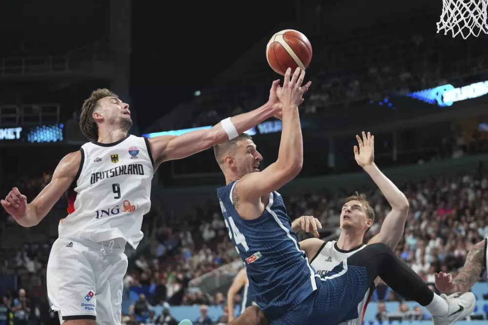 Germany's Franz Wagner, left, Slovenia's Alen Omic, centre, Germany's Justus Hollatz in action during the Eurobasket, European Basketball Championship quarter final match between Germany and Slovenia at the Riga Arena in Riga, Latvia, Wednesday, Sept. 10, 2025. (AP Photo/Sergei Grits)