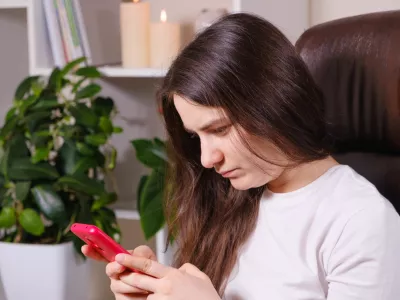 Pri gledanju v zaslon imamo običajno glavo nekoliko nagnjeno naprej. To velja za vse uporabnike, ne zgolj za dekleta. / Foto: Istock