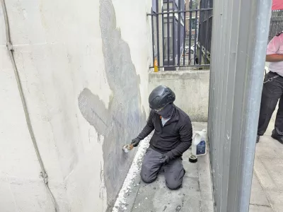 A worker removes the new artwork by Banksy, which shows a judge attacking a protester with a gavel, after it appeared at the Royal Courts of Justice in London on Monday, on Wednesday, Sept. 10, 2025. (Danny Halpin/PA via AP)