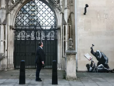 A person looks at a new mural by anonymous artist Banksy on the Royal Courts of Justice in London, Britain, September 9, 2025. REUTERS/Toby Melville