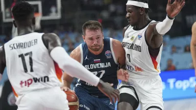 Germany's Dennis Schroder, left, Slovenia's Luka Doncic, centre, Germany's Isaac Bonga during the Eurobasket, European Basketball Championship quarter final match between Germany and Slovenia at the Riga Arena in Riga, Latvia, Wednesday, Sept. 10, 2025. (AP Photo/Sergei Grits)